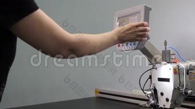 工人正在用平板电脑编程一台数控缝纫机。 操作人员设置数控机床。